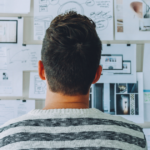 Man looking at cork board of project plans