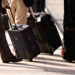 Person pushing luggage down street