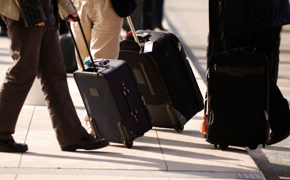 Person pushing luggage down street