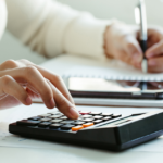 Person typing on a calculator