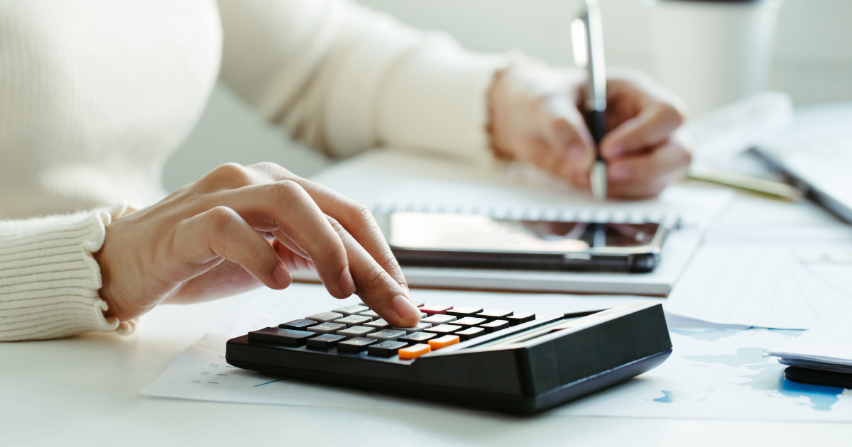 Person typing on a calculator