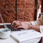 Person working on laptop at a cafe