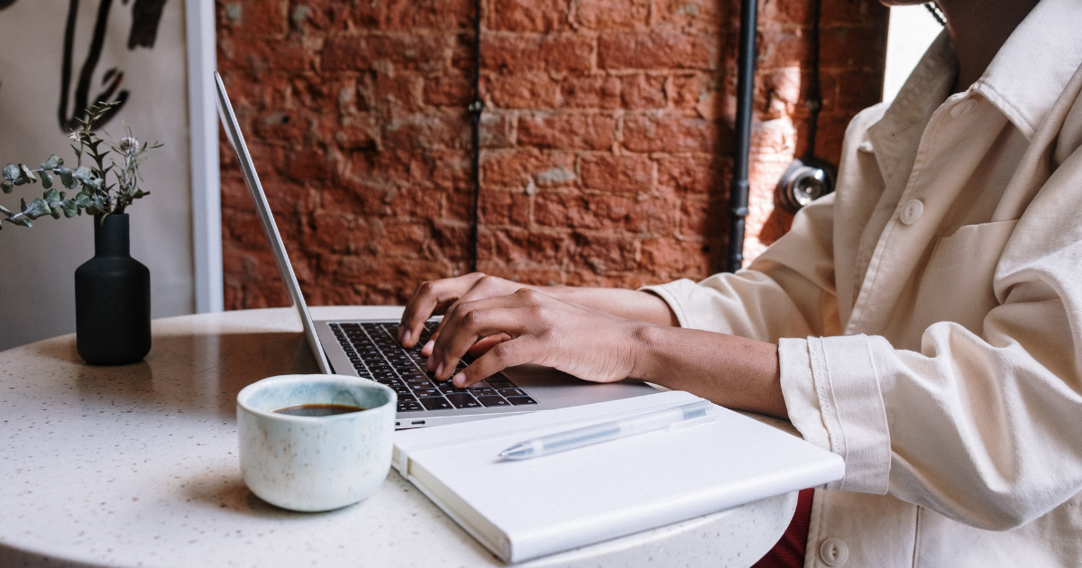 Person working on laptop at a cafe