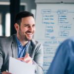 Happy business owner in front of white board