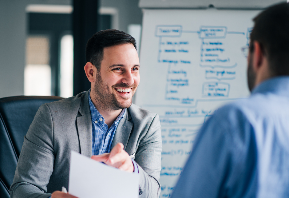 Happy business owner in front of white board