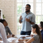 Business owner standing at a work meeting