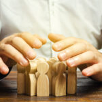 Person with wooden blocks shaped as people - Concept of Human Resource Management