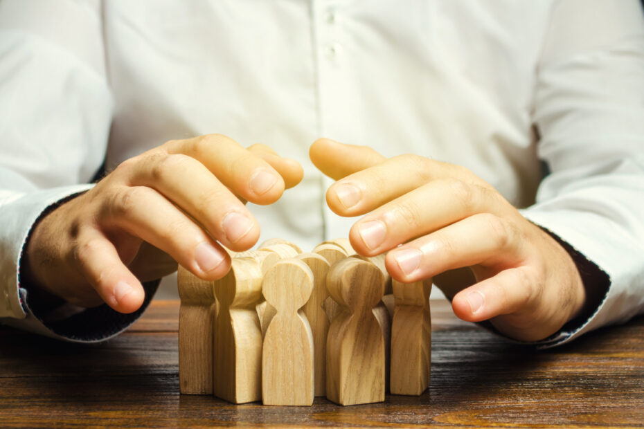 Person with wooden blocks shaped as people - Concept of Human Resource Management