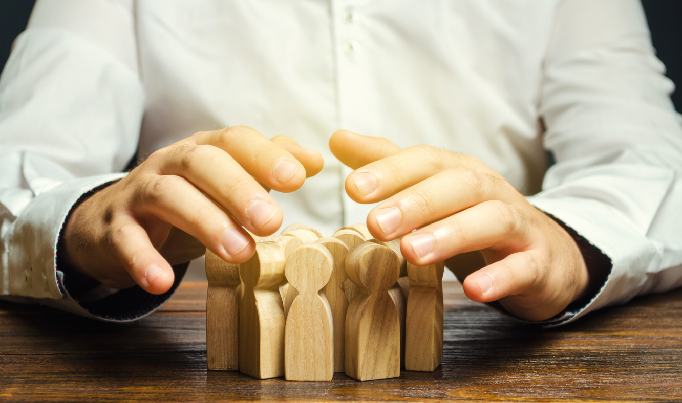 Person with wooden blocks shaped as people - Concept of Human Resource Management