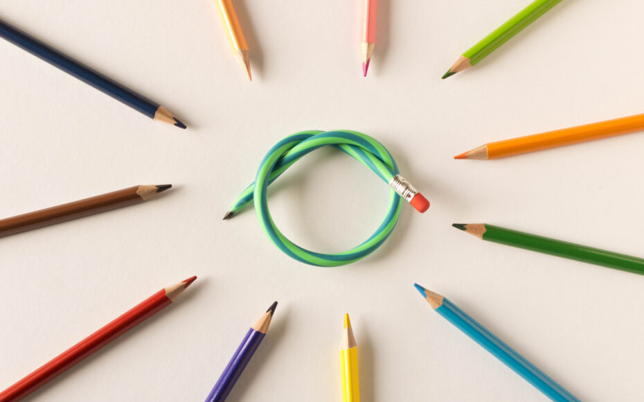 Colored pencils with one flexible pencil on white background