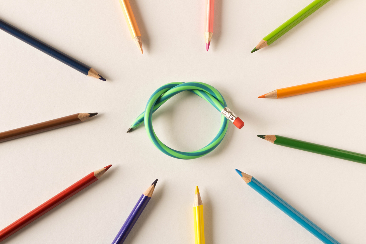 Colored pencils with one flexible pencil on white background