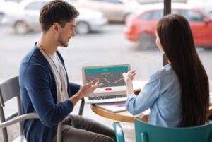 People having conversation outside on laptop