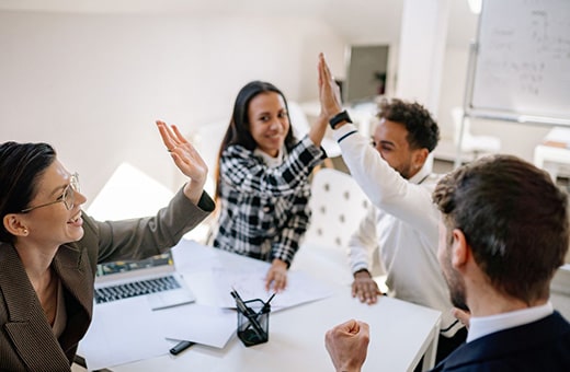 BCN Services clients giving high fives around table