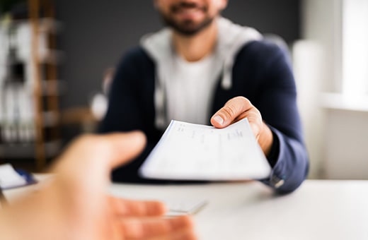 Man handing out paycheck