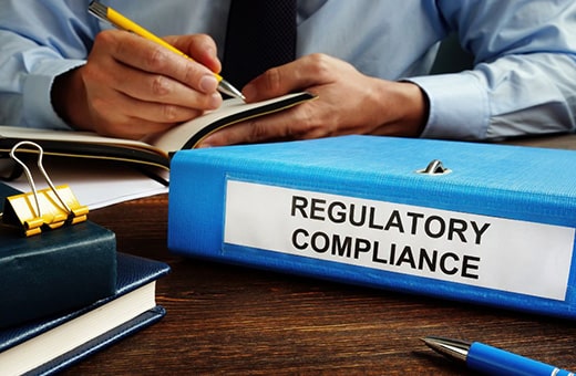 Regulatory compliance binder on desk