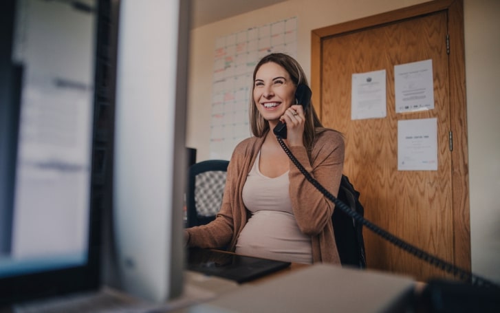 Pregnant BCN Services client on the phone